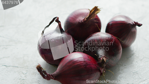 Image of Red onion bulbs on white table