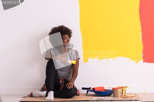 Image of back female painter sitting on floor