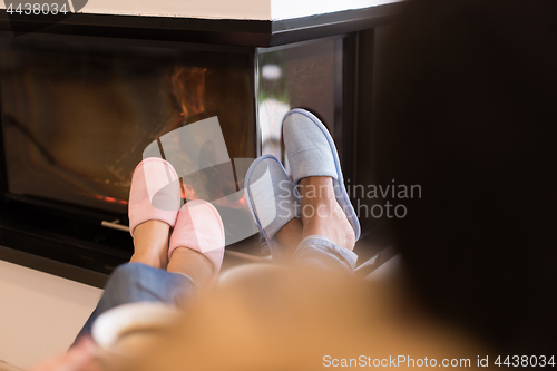 Image of Young multiethnic couple  in front of fireplace