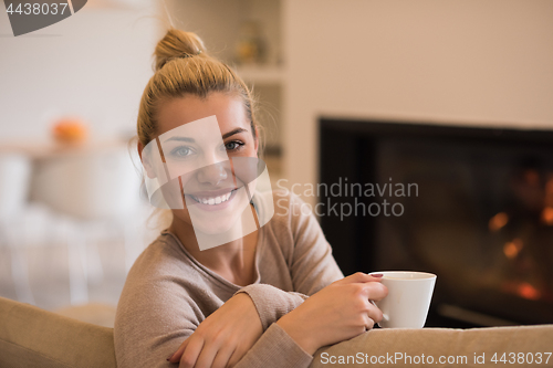 Image of woman with a mug near a fireplace