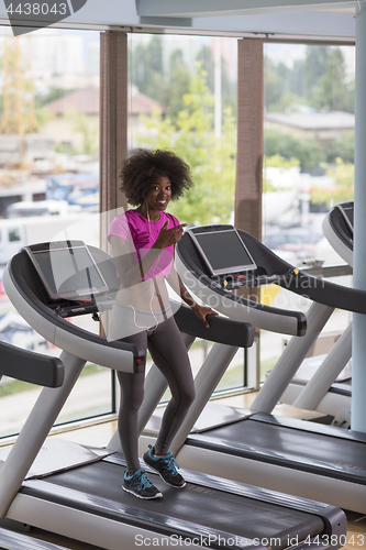 Image of afro american woman running on a treadmill