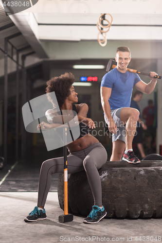 Image of multiethnic couple after workout with hammer