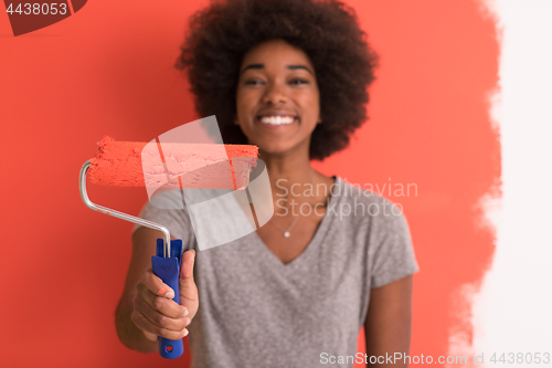 Image of black woman painting wall