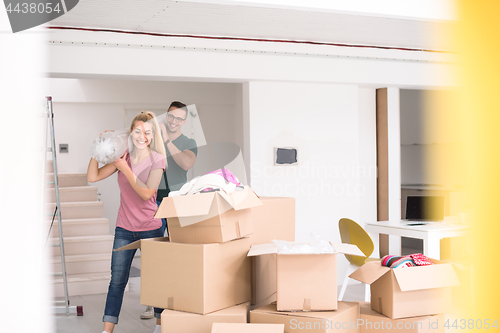 Image of couple carrying a carpet moving in to new home