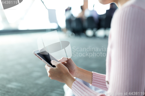 Image of Woman using cellphone in meeting room