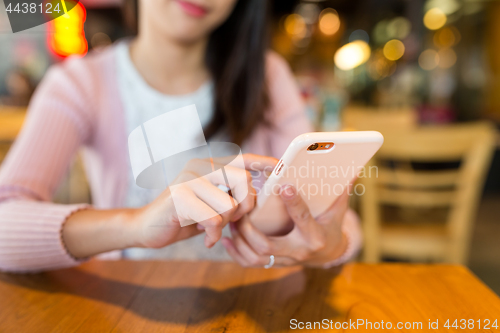 Image of Woman use of mobile phone in cafe