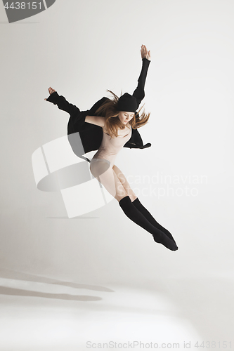 Image of Young beautiful dancer in beige swimsuit dancing on gray background