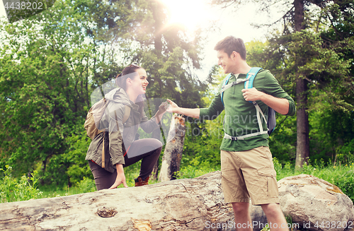 Image of smiling couple with backpacks hiking