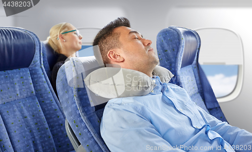 Image of man sleeping in plane with cervical neck pillow