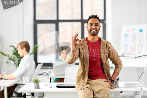 Image of smiling indian man showing ok hand sign at office