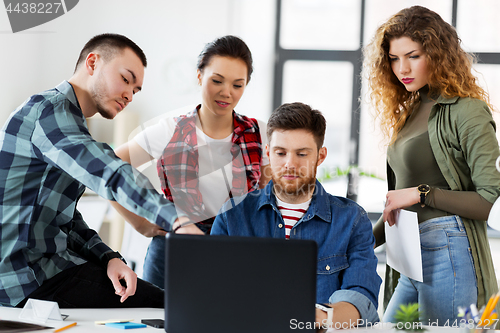 Image of creative team with laptop working at office