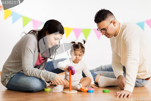 Image of baby girl with parents playing with pyramid toy