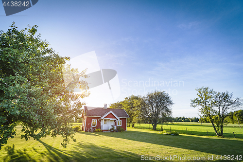 Image of Small red house on a swedish countryside landscape