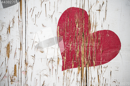 Image of Red heart scratched in wood in red color