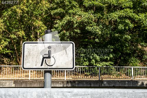 Image of Dirty handicap sign with a wheel chair