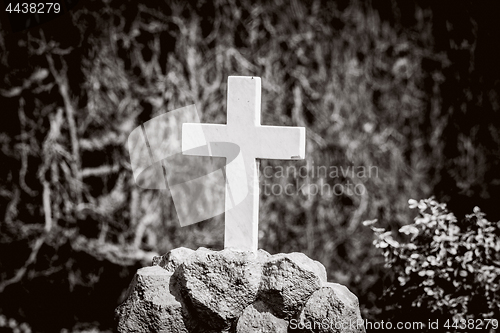 Image of White cross on a tomb in sepia colors