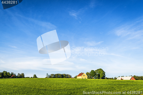 Image of Yellow farmhouse on a rural green field