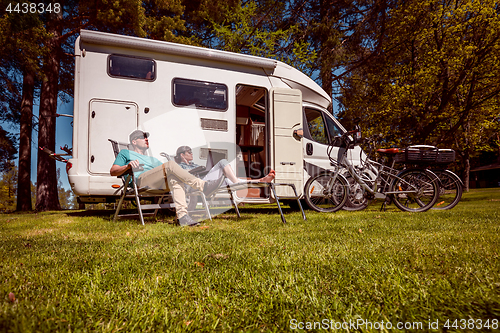 Image of Woman with a man resting near motorhomes in nature. Family vacat