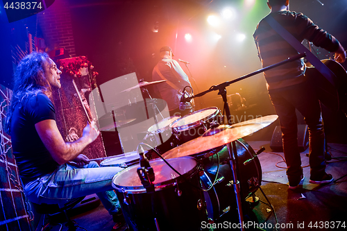 Image of Drummer playing on drum set on stage.
