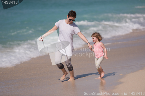 Image of mother and daughter running on the beach