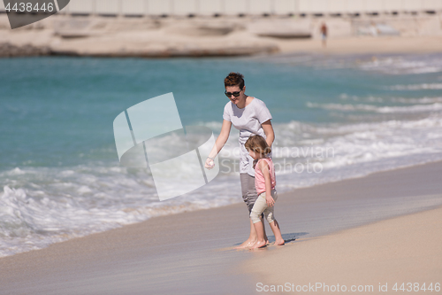 Image of mother and daughter running on the beach