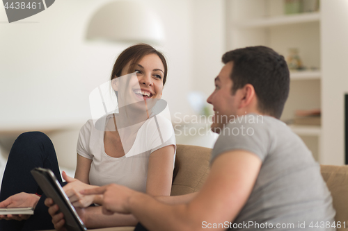Image of couple relaxing at  home with tablet computers