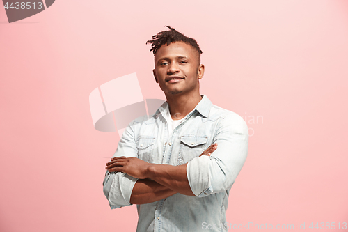 Image of The happy business man standing and smiling against pink background.