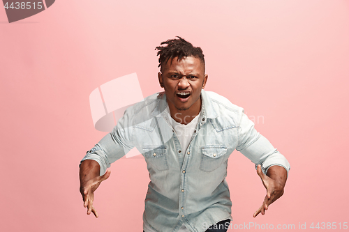 Image of The young emotional angry afro man screaming on pink studio background