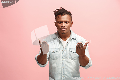 Image of Beautiful male half-length portrait isolated on pink studio backgroud. The young emotional surprised man