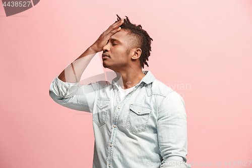 Image of African American Man having headache. Isolated over pink background.