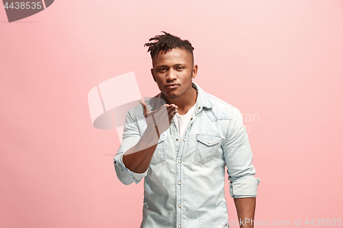 Image of Portrait of attractive Afro-American man with air kiss isolated over pink background