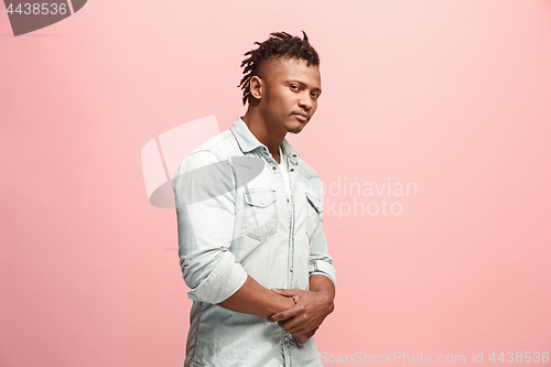 Image of Suspiciont. Doubtful pensive man with thoughtful expression making choice against pink background