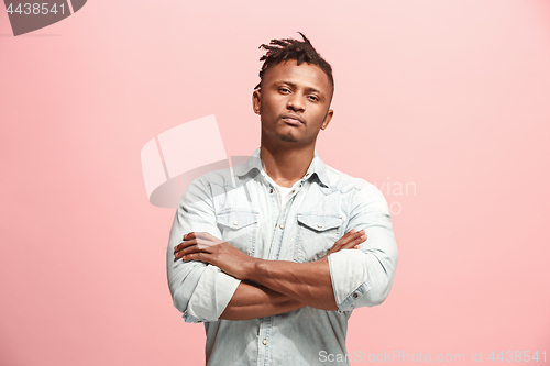 Image of Suspiciont. Doubtful pensive man with thoughtful expression making choice against pink background