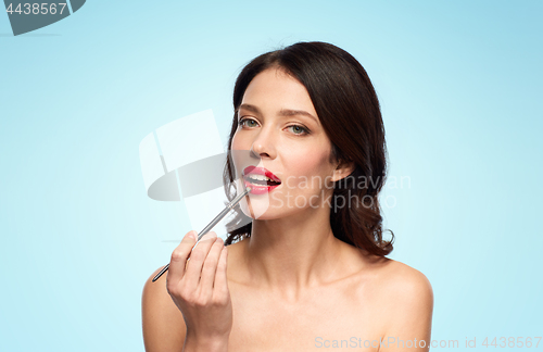 Image of beautiful woman with make up brush for lipstick