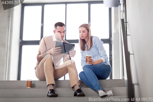Image of man and woman with tablet pc and coffee on stairs