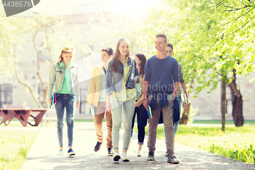 Image of group of happy teenage students walking outdoors