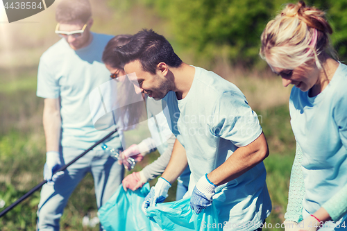 Image of volunteers with garbage bags cleaning park area