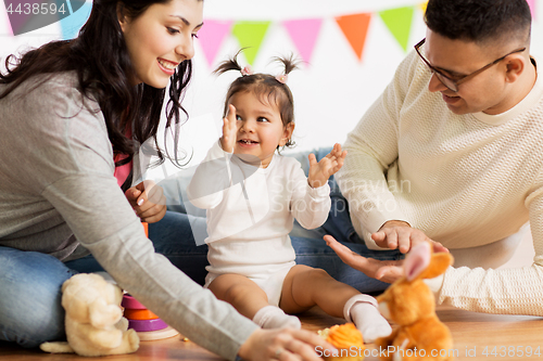 Image of baby girl with parents clapping hands