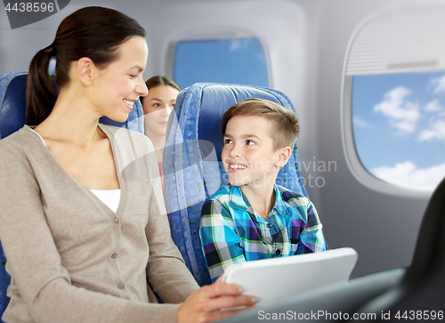 Image of happy family with tablet pc sitting in plane