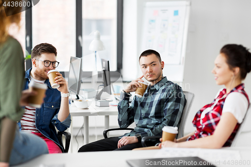 Image of creative team drinking coffee at office