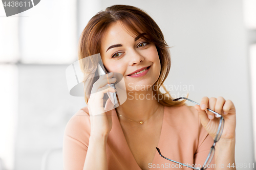 Image of businesswoman calling on smartphone at office