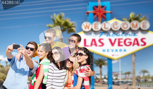 Image of group of happy friends taking selfie by cell phone