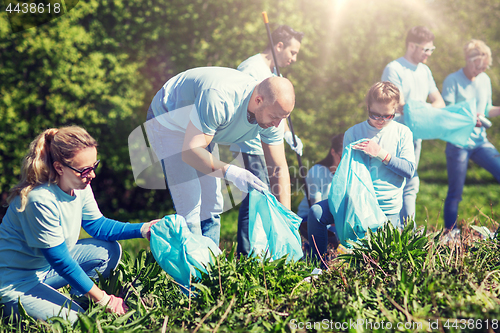 Image of volunteers with garbage bags cleaning park area