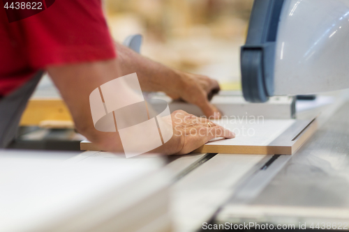 Image of carpenter with panel saw and fibreboard at factory