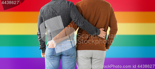 Image of close up of hugging male gay couple over rainbow