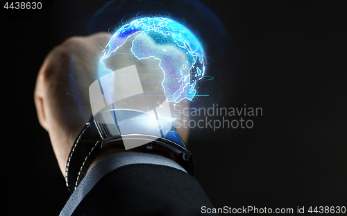 Image of hand with smart watch and earth hologram