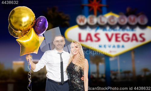 Image of happy couple with party caps and balloons