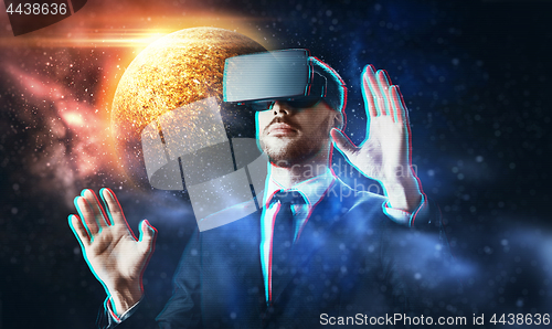 Image of businessman in virtual reality headset over space