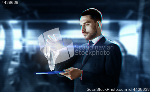 Image of businessman with transparent tablet and hologram
