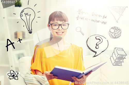 Image of smiling young asian woman reading book at home